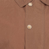 Close-up of a brown Tom Beckbe shirt with buttons and collar, ideal under the Tom Beckbe Piedmont Jacket.