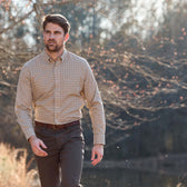 Man in a Tom Beckbe Knapp Cotton Twill Shirt and dark pants walking outdoors near trees on a sunny day.