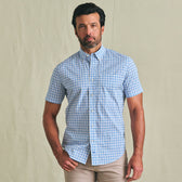 Man wears the Tom Beckbe Powell Performance Shirt (Short Sleeve) in blue and white checks with beige pants.