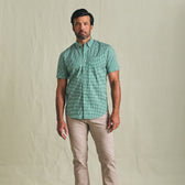 Man wearing Tom Beckbe’s Powell Performance Shirt (Short Sleeve) and light beige pants against a plain background.