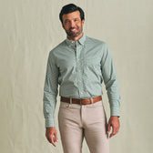 Man in a Tom Beckbe Powell Performance Shirt and beige pants, standing against a plain light background.