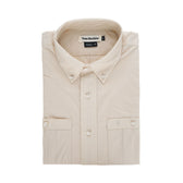 Folded Tidewater Shirt by Tom Beckbe in beige, short sleeve with UPF 30+, collar, pockets; set on a white background.