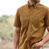 A man in a Tom Beckbe Tidewater Shirt (short sleeve) with UPF 30+ and pockets has one hand in his pants pocket.