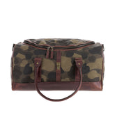 The Tom Beckbe Classic Camo Weekender Duffel Bag has brown leather handles and trim, shown on a white background.