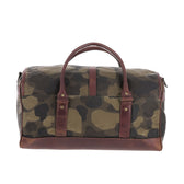 The Tom Beckbe Classic Camo Weekender Duffel Bag features brown leather handles and trim, shown on a white background.