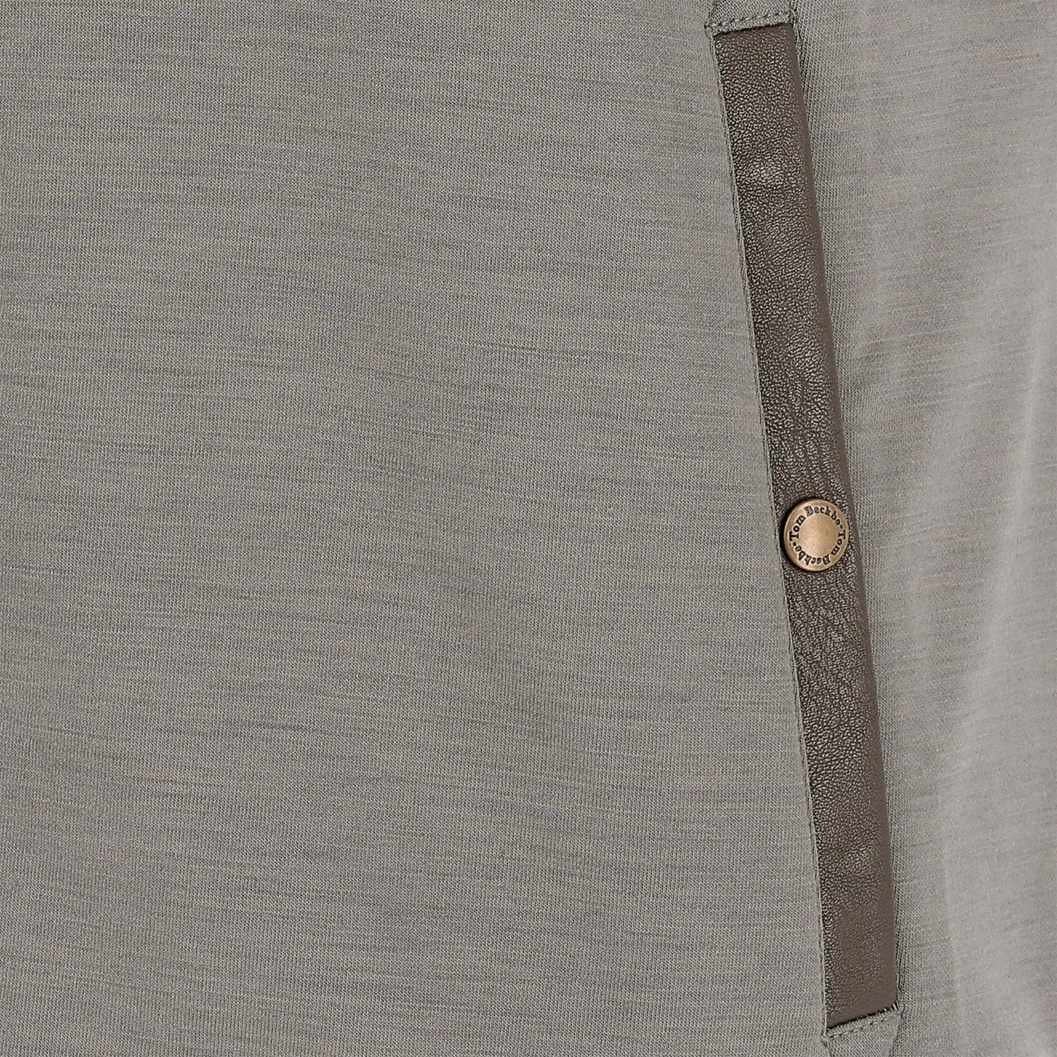 Close-up of the Tom Beckbe Tucker Fleece Quarter Zip featuring brown leather trim and a gold button detail.
