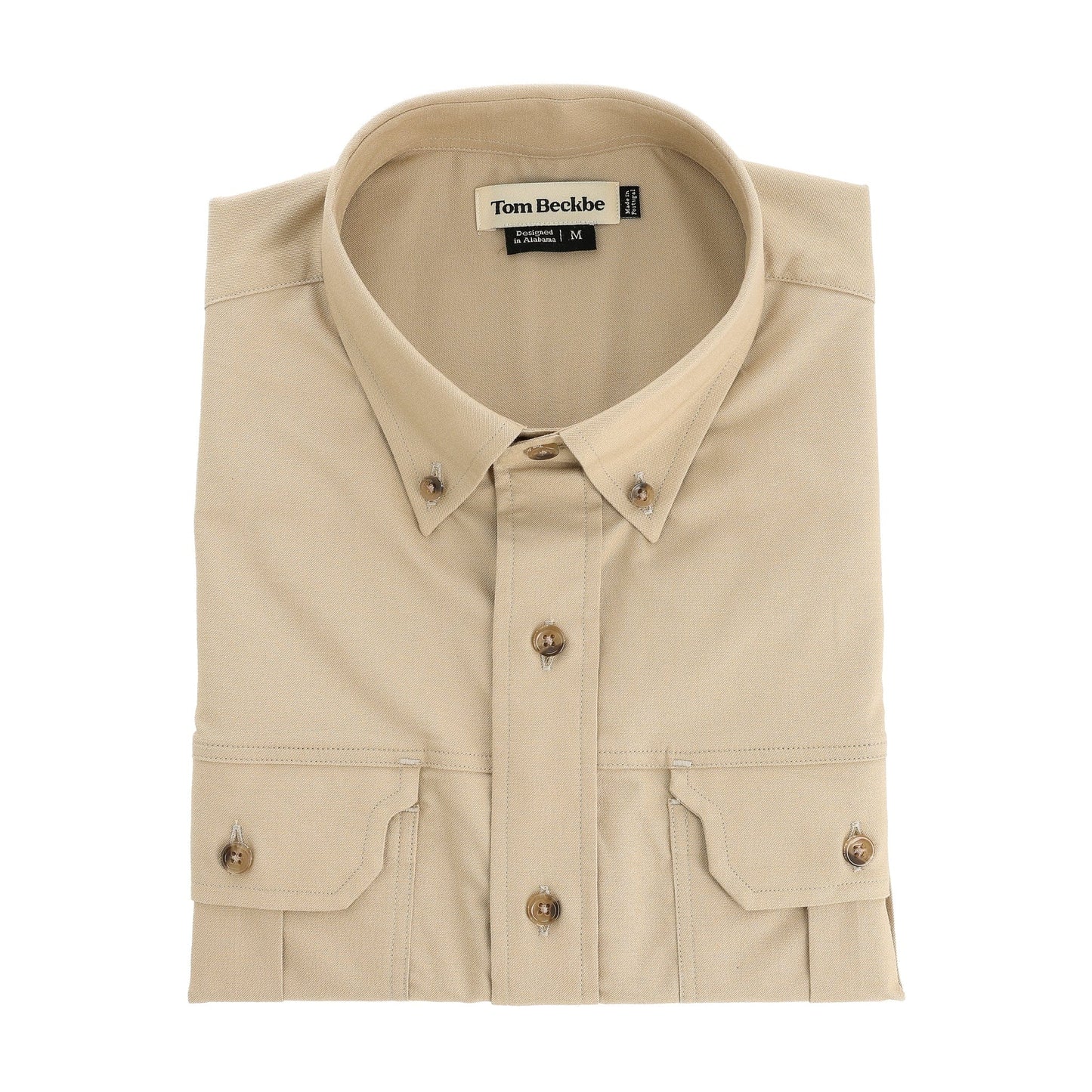 Folded beige cotton Uplander Shirt by Tom Beckbe with front pockets and a visible inside collar label.