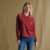 Woman in Tom Beckbe Women’s Shelby Fleece Pullover and jeans stands before tan backdrop—the perfect cool-weather layer.