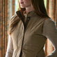 A woman wears the Tom Beckbe Womens Tyler Quilted Vest over a sweater, standing indoors and facing slightly to the side.