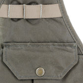Close-up of a khaki fabric pocket with a snap button and beige strap loops above it.
