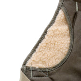 Close-up of a garment showing brown outer fabric and soft beige fleece lining with visible stitching.