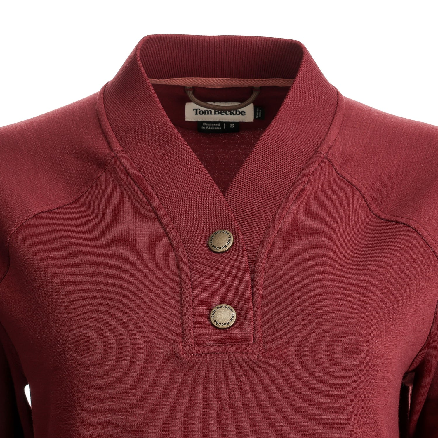 Close-up of a maroon Tom Beckbe Women’s Shelby Fleece Pullover with shawl collar, two buttons, and inner brand label.