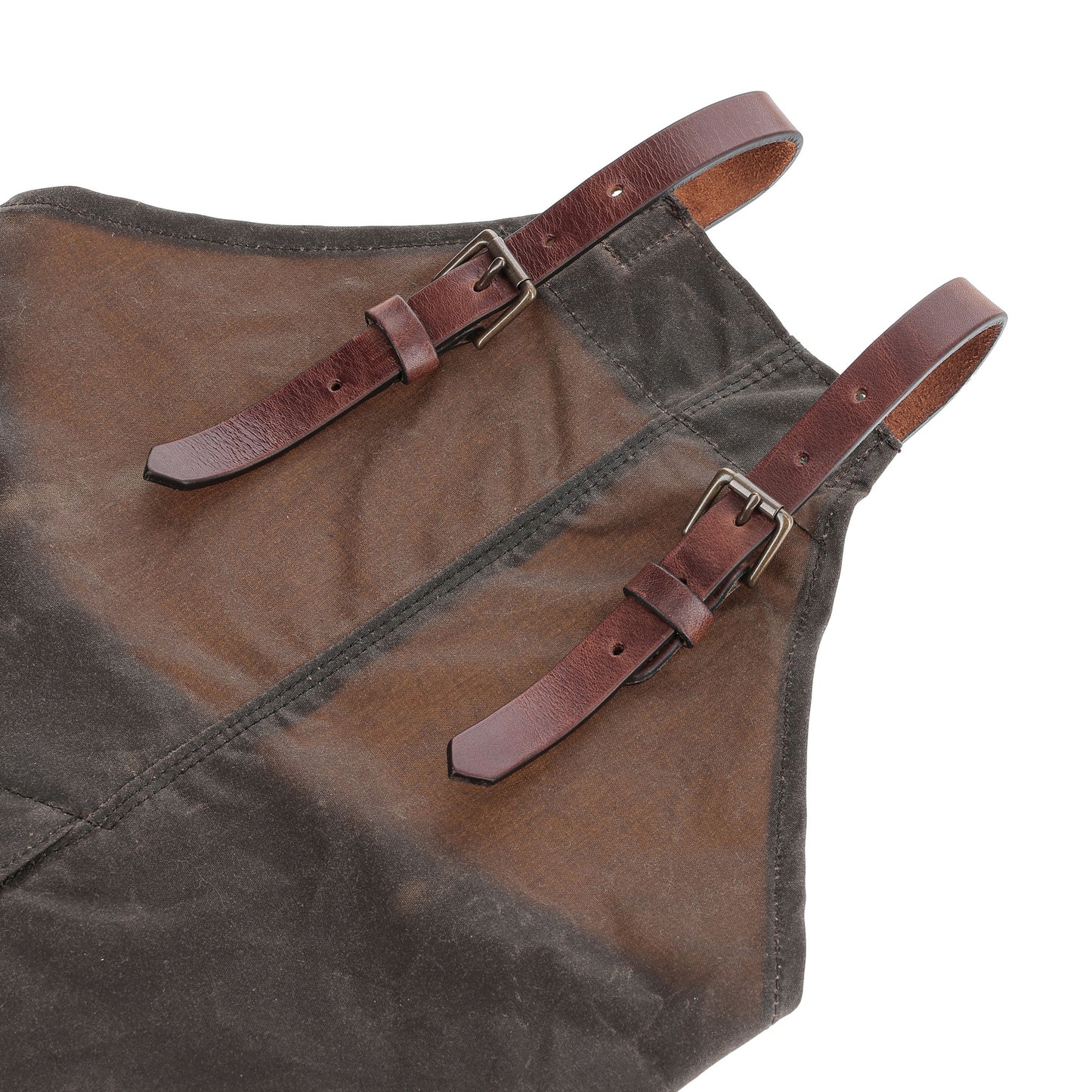 Close-up of two brown leather buckle straps on Tom Beckbe Waxed Canvas Chaps with visible stitching.