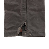 Close-up of the Tom Beckbe Waxed Canvas Chaps hem with zipper and snap button closures.