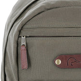 Close-up of the Tom Beckbe DU Canvas Backpack with duck logo patch, brown zipper pull, and padded laptop sleeve.