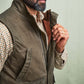 Man wearing a brown plaid shirt and Tom Beckbe DU Kinsman Vest, holding it open to show the waxed cotton construction.