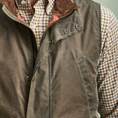 Person wearing a Tom Beckbe DU Kinsman Vest over a brown and white checkered button-up; only torso is visible.