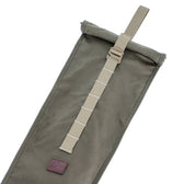 The DU Roll Top Gun Sleeve by Tom Beckbe is a gray canvas pouch with a tan adjustable strap, inspired by classic gun slip design.