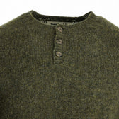 Close-up of Tom Beckbe Albemarle Henley Sweater in green wool, round neck, and three brown buttons. Made in Scotland.